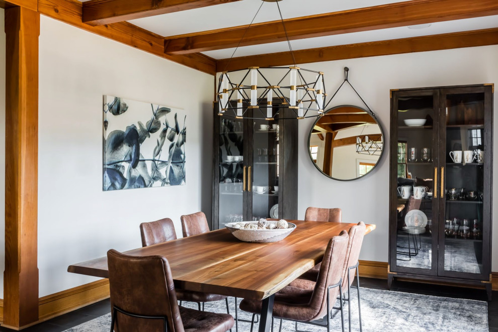 Photo of a country open plan dining in Raleigh with white walls, dark hardwood floors, black floor and exposed beam.