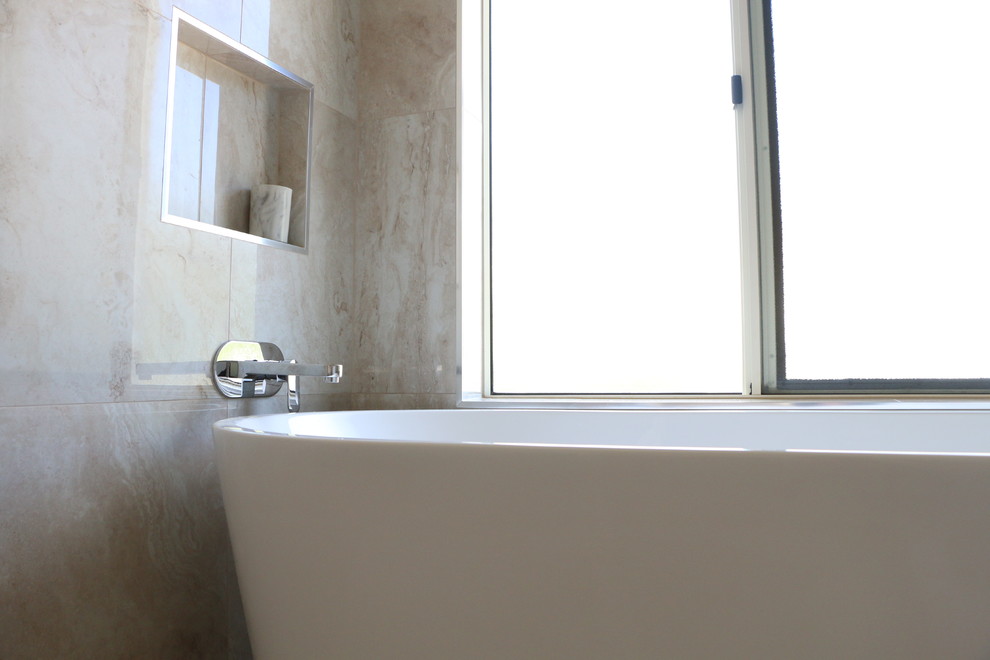 Photo of a large contemporary master bathroom in Brisbane with a freestanding tub, a corner shower, beige tile, porcelain tile, beige walls, porcelain floors, a vessel sink, solid surface benchtops, beige floor, a hinged shower door and white benchtops.