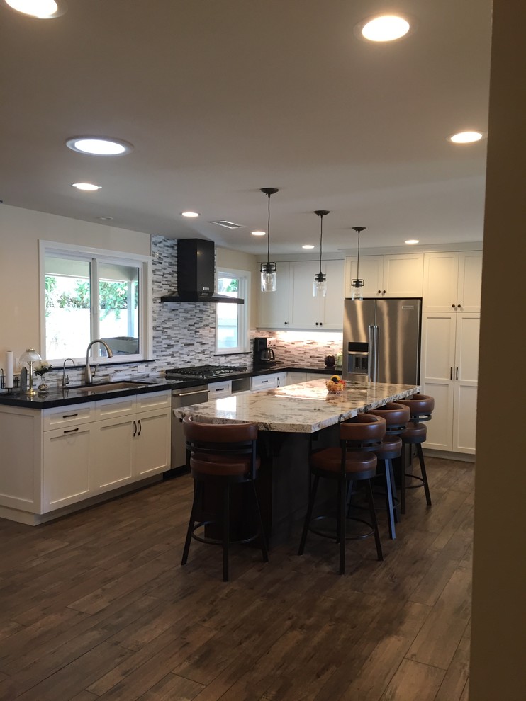 Kitchen - transitional kitchen idea in Orange County with an undermount sink, shaker cabinets, white cabinets, quartz countertops, an island and black countertops