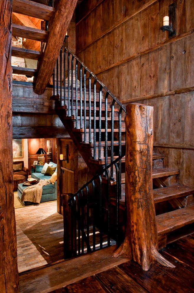 Photo of a country wood u-shaped staircase in Other with wood risers and metal railing.