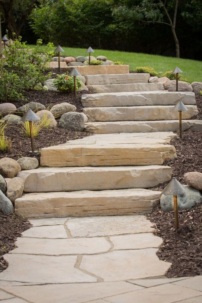 This is an example of a mid-sized transitional full sun backyard stone landscaping in Chicago.