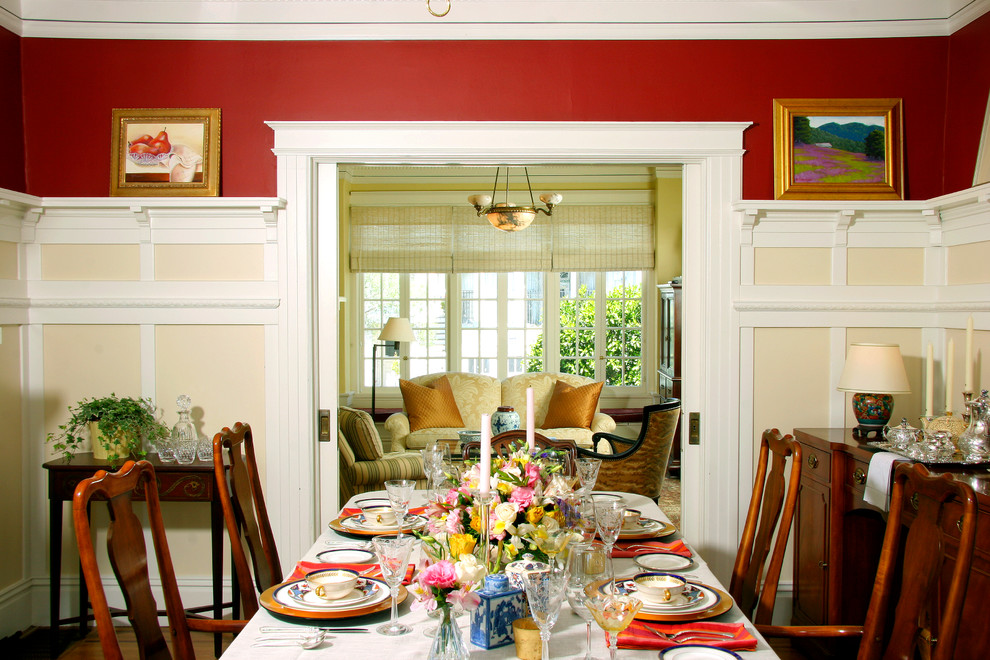 Traditional separate dining room in Other with red walls, dark hardwood floors, a standard fireplace and a brick fireplace surround.