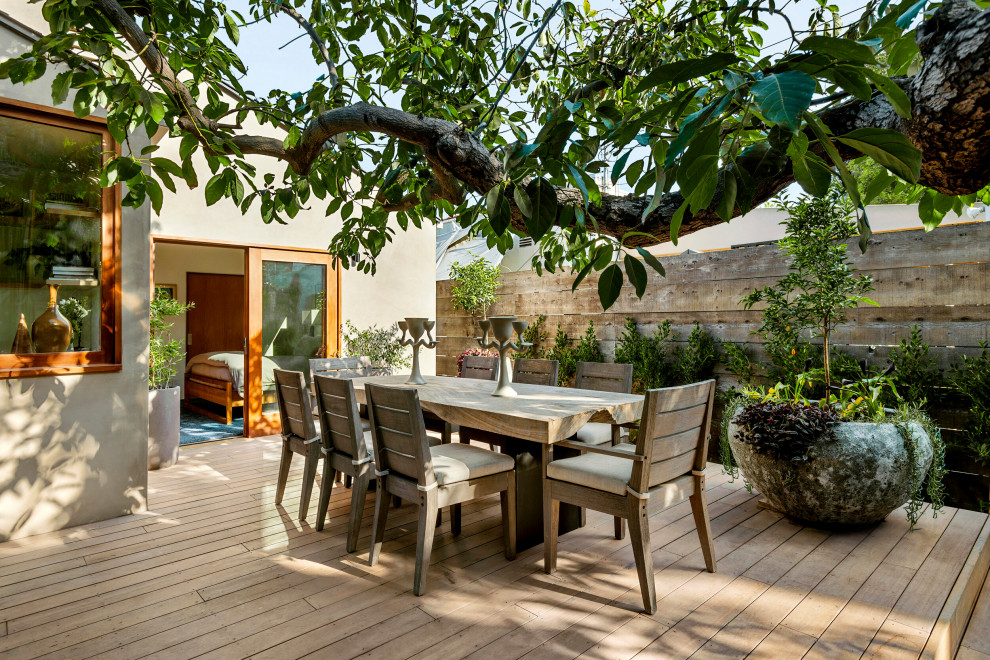 Foto de terraza planta baja actual de tamaño medio sin cubierta en patio trasero con privacidad y barandilla de madera