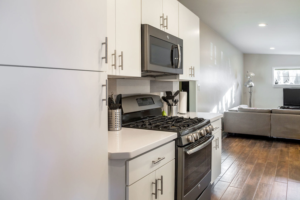 Inspiration for a transitional u-shaped porcelain tile open concept kitchen remodel in Phoenix with a farmhouse sink, shaker cabinets, white cabinets, quartz countertops, multicolored backsplash, porcelain backsplash, stainless steel appliances and an island