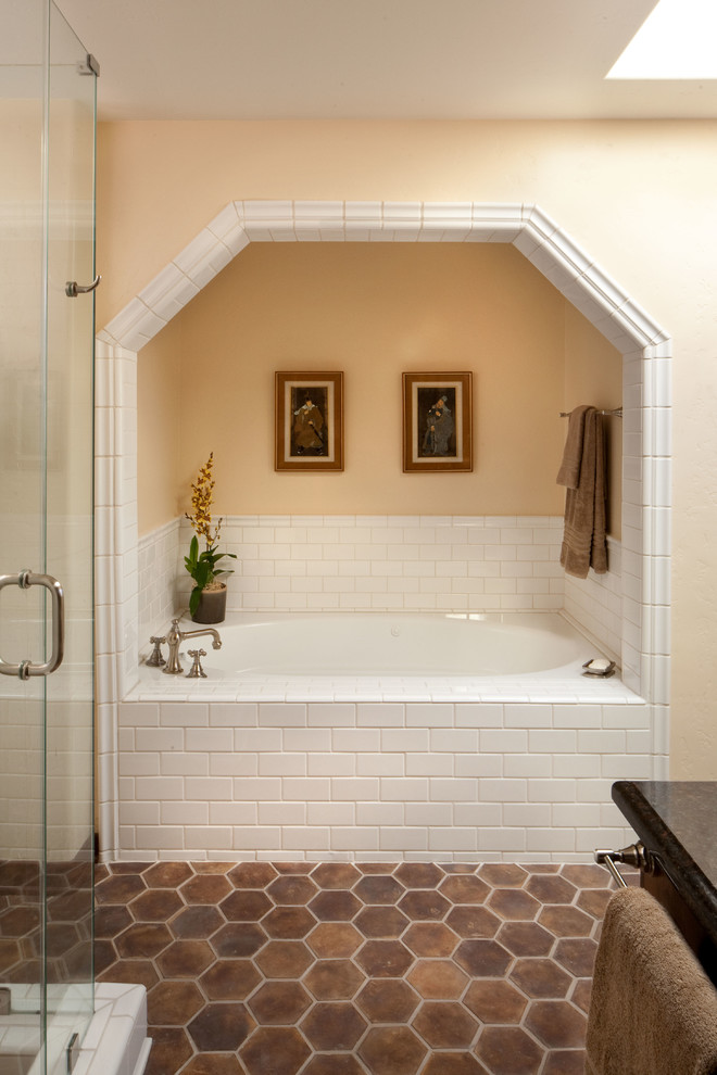 Mid-sized mediterranean master bathroom in Los Angeles with shaker cabinets, dark wood cabinets, an alcove tub, a corner shower, brown tile, beige walls, terra-cotta floors and an undermount sink.