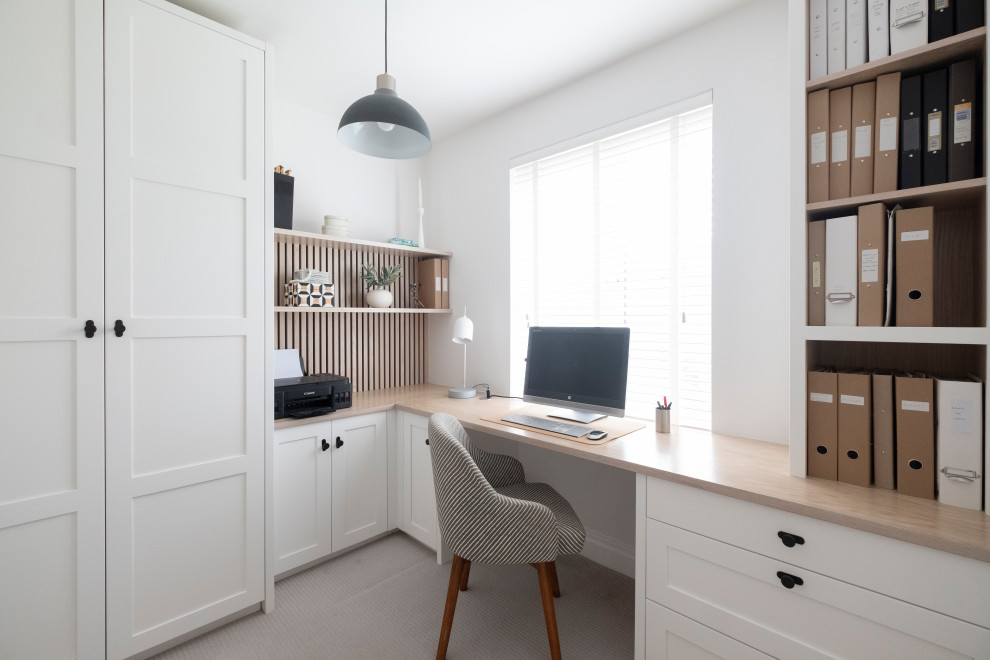 Modelo de despacho retro pequeño con paredes blancas, moqueta, escritorio empotrado y suelo gris