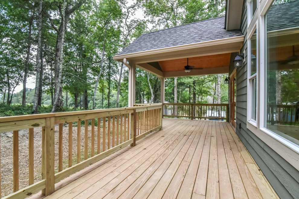 Mid-sized arts and crafts backyard deck in Other with a roof extension.
