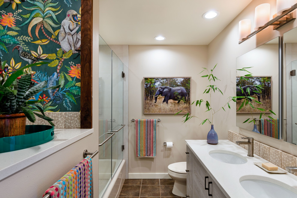 This is an example of a small contemporary kids bathroom in Seattle with flat-panel cabinets, an alcove tub, a shower/bathtub combo, beige walls, an undermount sink, brown floor, a hinged shower door, white benchtops, a double vanity, light wood cabinets, ceramic floors, engineered quartz benchtops and a built-in vanity.