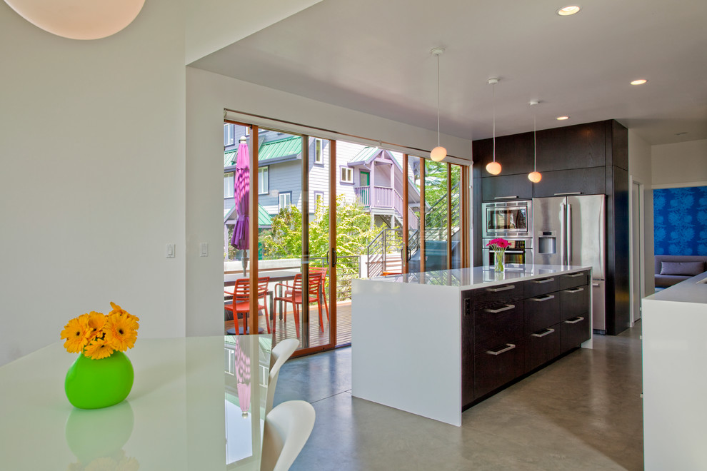 Contemporary eat-in kitchen in Seattle with flat-panel cabinets, dark wood cabinets and stainless steel appliances.