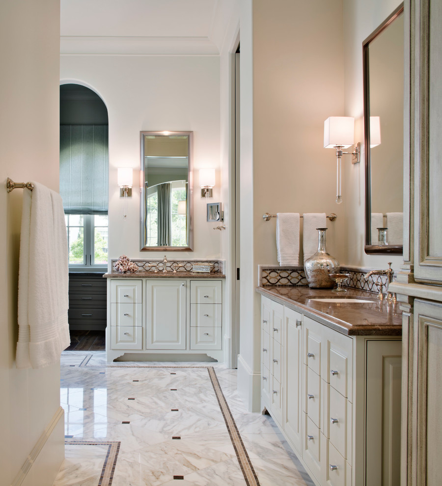This is an example of a large traditional master bathroom in Houston with an undermount sink, raised-panel cabinets, beige cabinets, marble benchtops and stone tile.