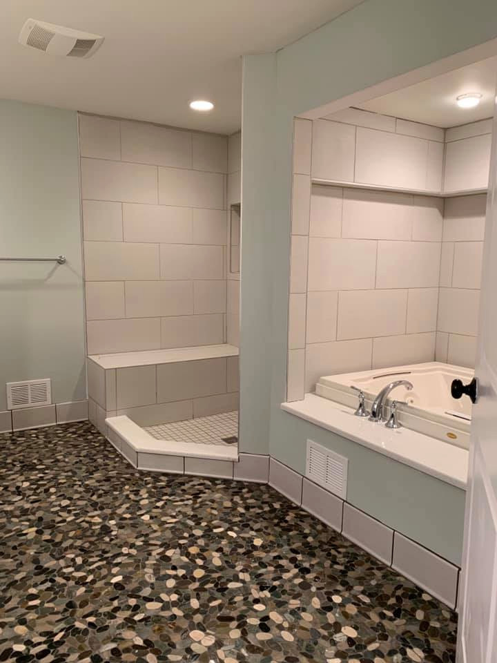 This is an example of a large master bathroom in Detroit with dark wood cabinets, an alcove tub, a corner shower, a one-piece toilet, blue walls, pebble tile floors, onyx benchtops, multi-coloured floor, an open shower, white benchtops, a niche, a double vanity and a built-in vanity.
