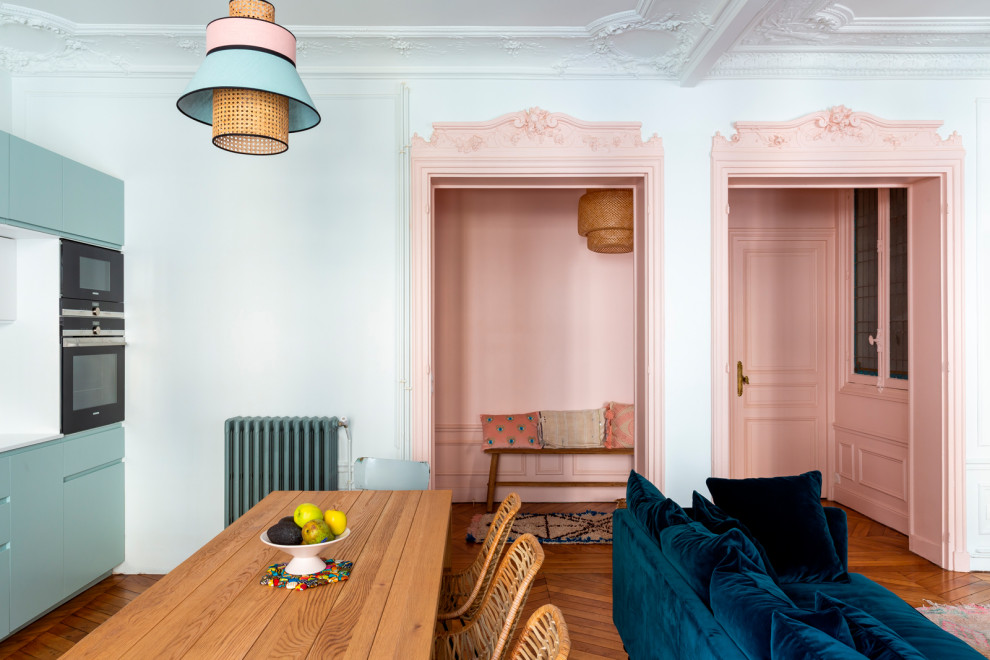 This is an example of a mid-sized contemporary entry hall in Paris with pink walls, medium hardwood floors, a single front door, brown floor and vaulted.
