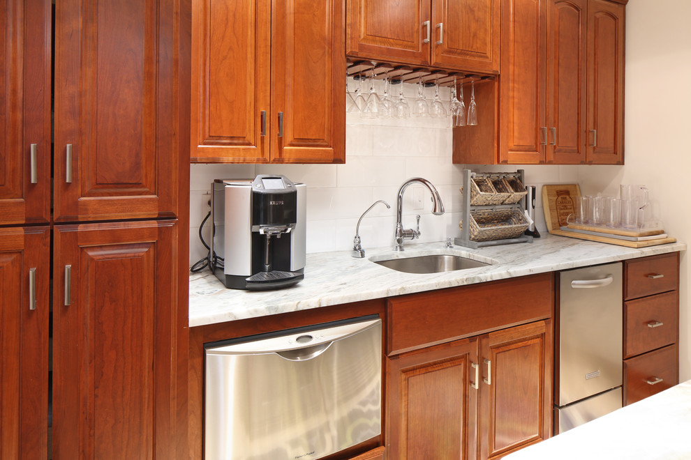 Example of a large transitional u-shaped porcelain tile and beige floor enclosed kitchen design in Boston with an undermount sink, raised-panel cabinets, medium tone wood cabinets, granite countertops, white backsplash, subway tile backsplash, stainless steel appliances, an island and white countertops