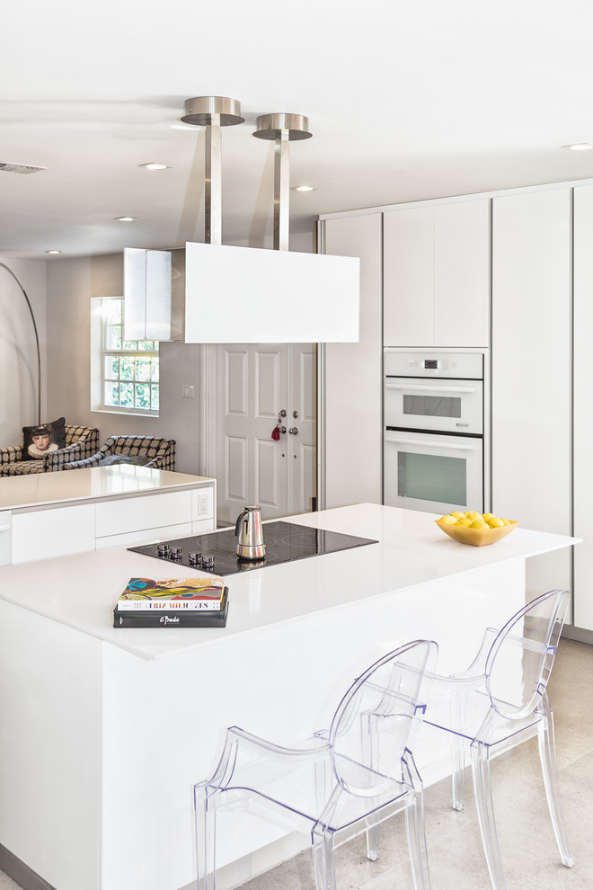 This is an example of a mid-sized eclectic l-shaped eat-in kitchen in Miami with an undermount sink, flat-panel cabinets, white cabinets, solid surface benchtops, multi-coloured splashback, ceramic splashback, stainless steel appliances, ceramic floors, with island and beige floor.
