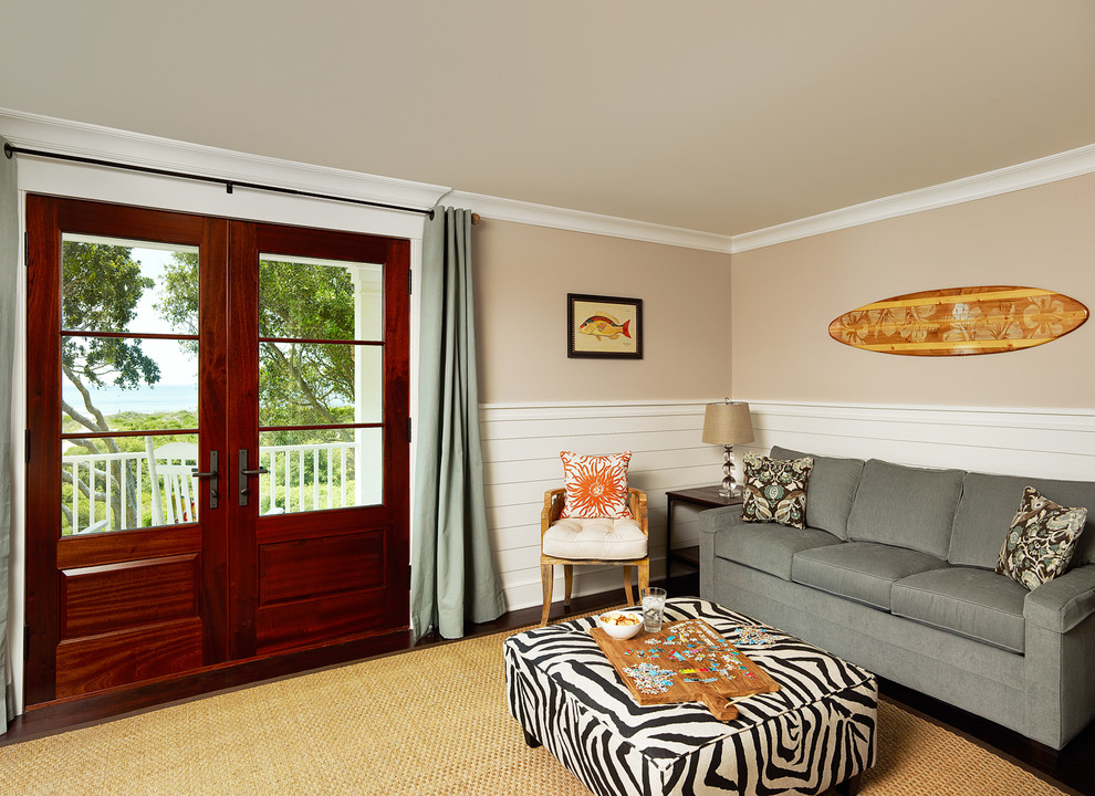 Photo of a tropical family room in Charleston with beige walls and dark hardwood floors.