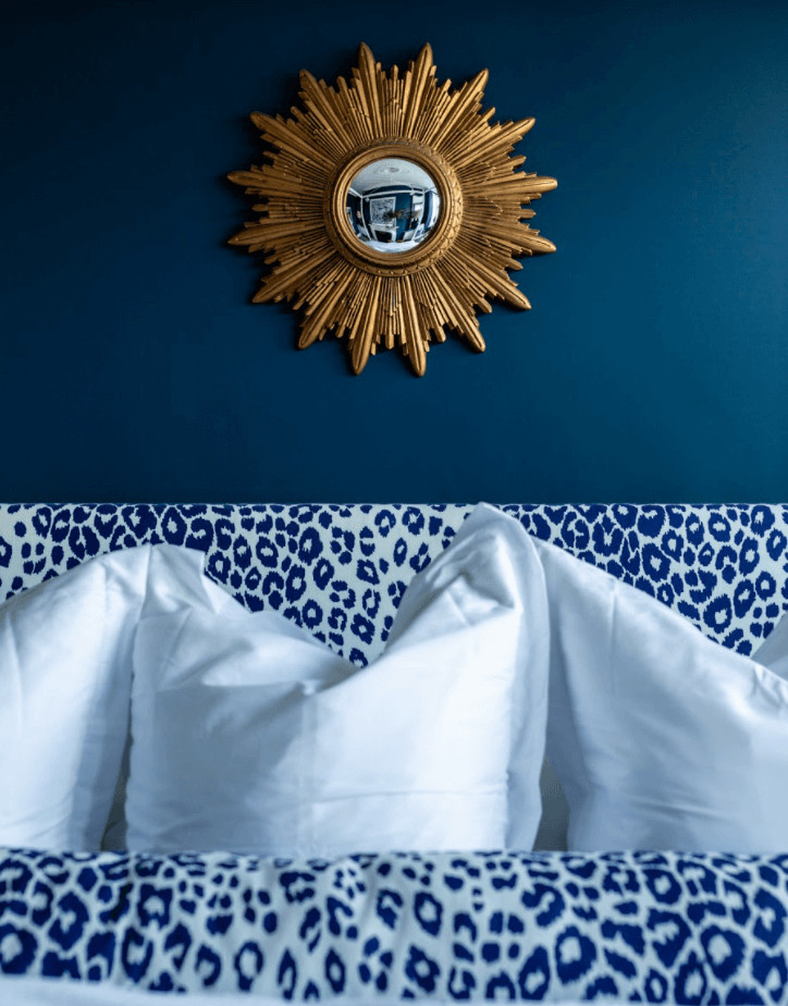 Ispirazione per una grande camera degli ospiti minimal con pareti blu, moquette, camino classico, pavimento beige e abbinamento di mobili antichi e moderni