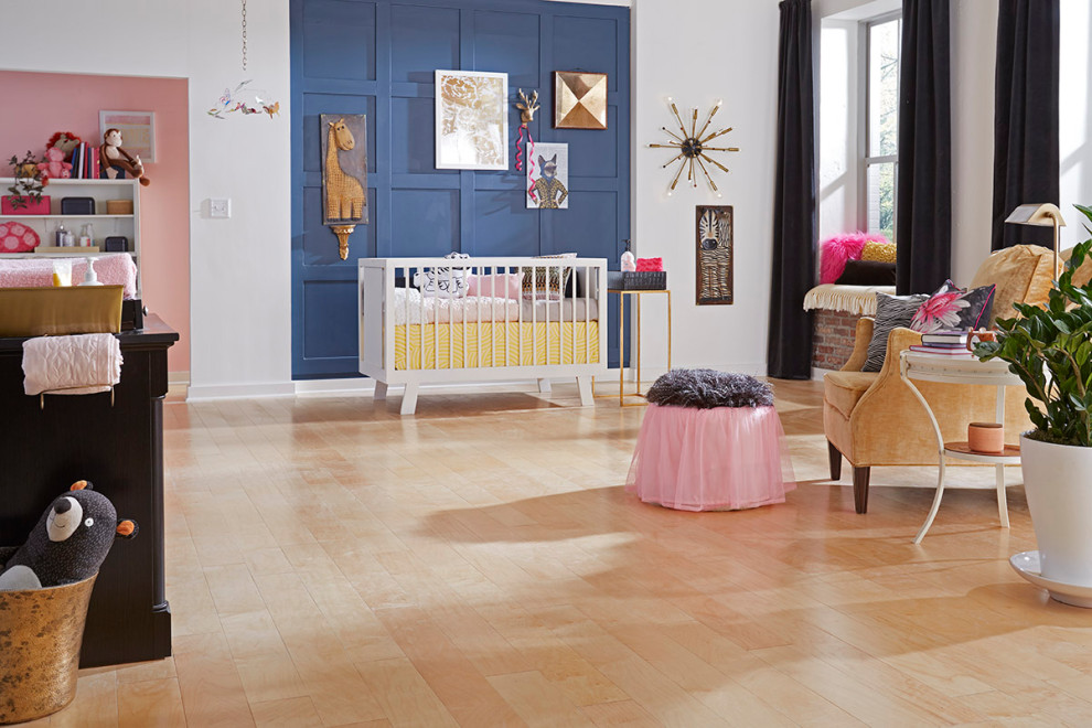 Design ideas for a large modern nursery for girls in Raleigh with pink walls, light hardwood floors and beige floor.
