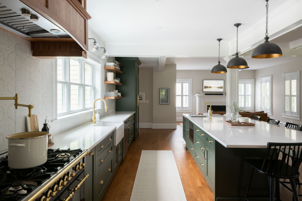 Eat-in kitchen - huge transitional medium tone wood floor and brown floor eat-in kitchen idea in Boston with a farmhouse sink, shaker cabinets, green cabinets, quartz countertops, beige backsplash, an island and white countertops