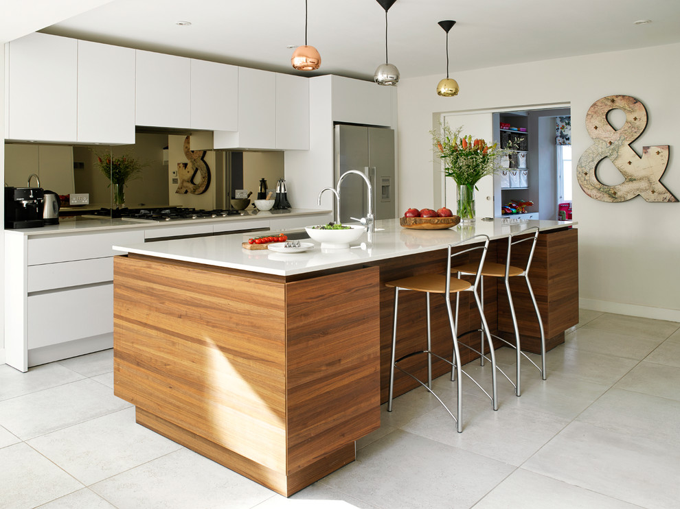 Inspiration for a contemporary l-shaped kitchen in London with with island, flat-panel cabinets, white cabinets and stainless steel appliances.