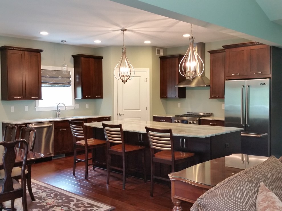 Large transitional l-shaped dark wood floor eat-in kitchen photo with a single-bowl sink, recessed-panel cabinets, dark wood cabinets, quartzite countertops, stainless steel appliances and an island