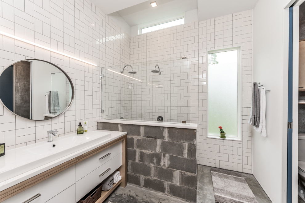 Mid-sized eclectic master bathroom in Houston with flat-panel cabinets, white cabinets, an open shower, a two-piece toilet, white tile, ceramic tile, grey walls, concrete floors, a drop-in sink, solid surface benchtops, grey floor, an open shower, white benchtops, a laundry, a single vanity and a built-in vanity.