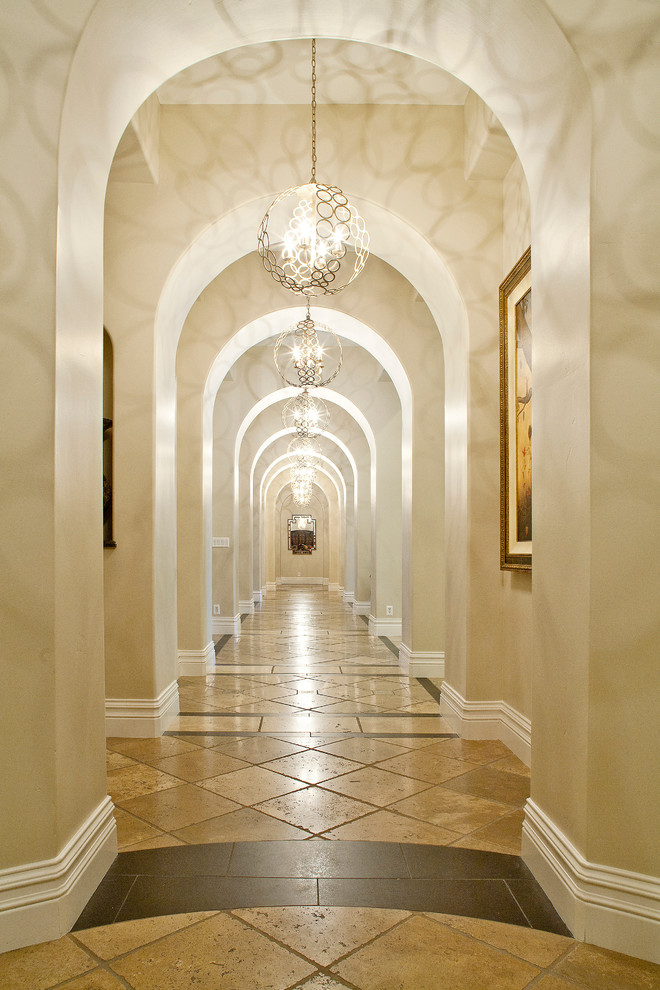 Large traditional hallway in Las Vegas with beige walls, travertine floors and brown floor.