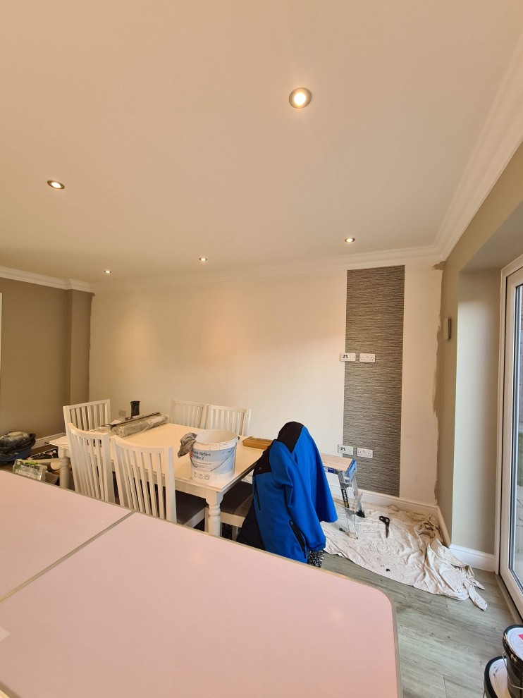 Inspiration pour une grande salle à manger ouverte sur le salon minimaliste avec un mur vert, sol en stratifié et un sol marron.