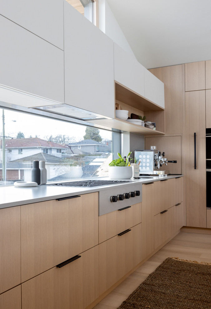 Ispirazione per una cucina scandinava di medie dimensioni con lavello da incasso, ante lisce, ante in legno chiaro e parquet chiaro