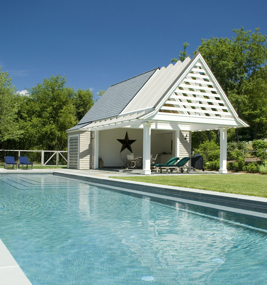 Photo of a large contemporary backyard rectangular lap pool in Other with a pool house and natural stone pavers.