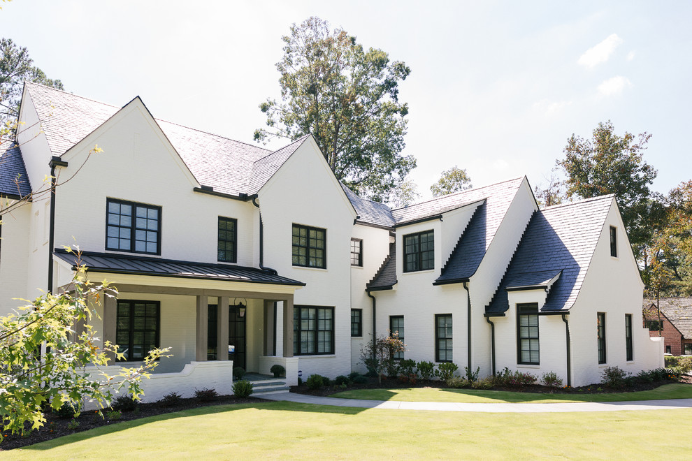 This is an example of a mid-sized transitional three-storey brick white house exterior in Atlanta with a gable roof, a mixed roof and a black roof.