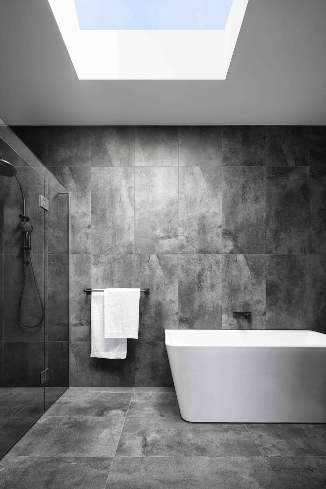 Modern inredning av ett vit vitt badrum, med svarta skåp, en öppen dusch, porslinskakel, grå väggar, klinkergolv i porslin, ett integrerad handfat, bänkskiva i kvarts, grått golv och med dusch som är öppen