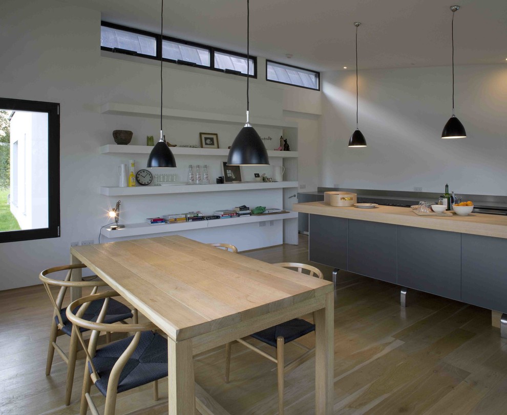Inspiration for a modern open plan kitchen in Dublin with black cabinets, wood benchtops and with island.
