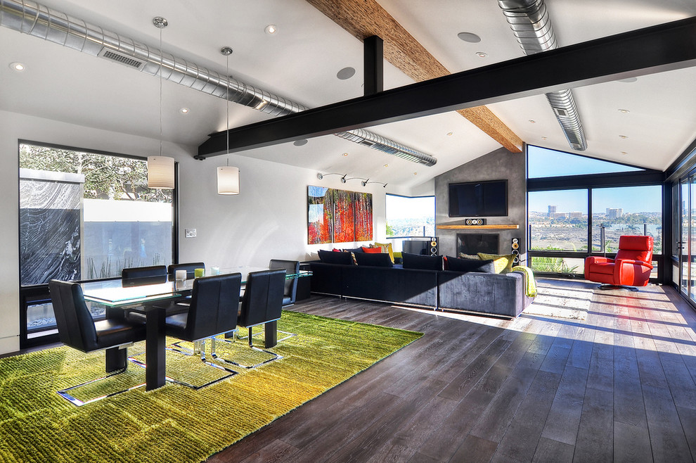 Example of a mid-sized trendy open concept medium tone wood floor and brown floor living room design in Orange County with white walls, a standard fireplace, a metal fireplace and a wall-mounted tv