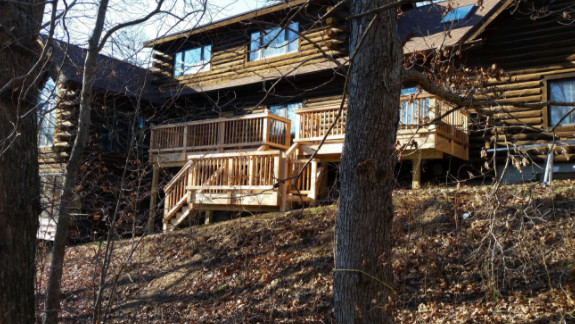 Inspiration for a large rustic beige two-story wood gable roof remodel with a shingle roof