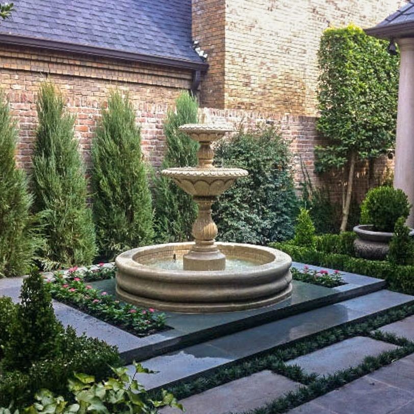 This is an example of a mid-sized mediterranean backyard formal garden in Dallas with a water feature and natural stone pavers.