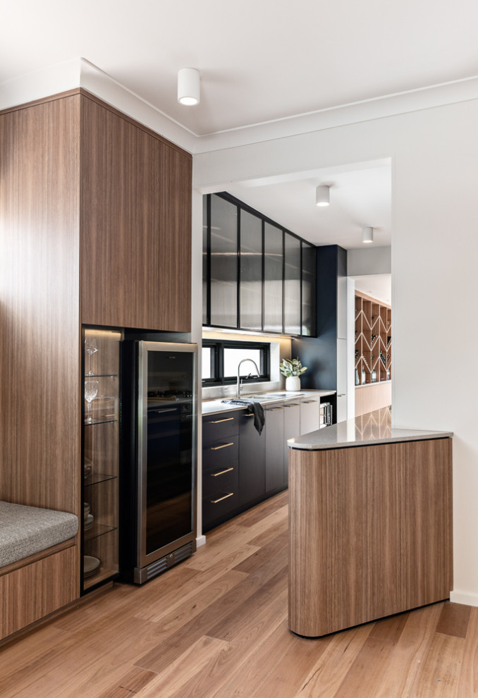 Design ideas for a mid-sized contemporary galley separate kitchen in Sydney with a double-bowl sink, blue cabinets, quartz benchtops, grey splashback, engineered quartz splashback, stainless steel appliances, medium hardwood floors, no island, brown floor and grey benchtop.