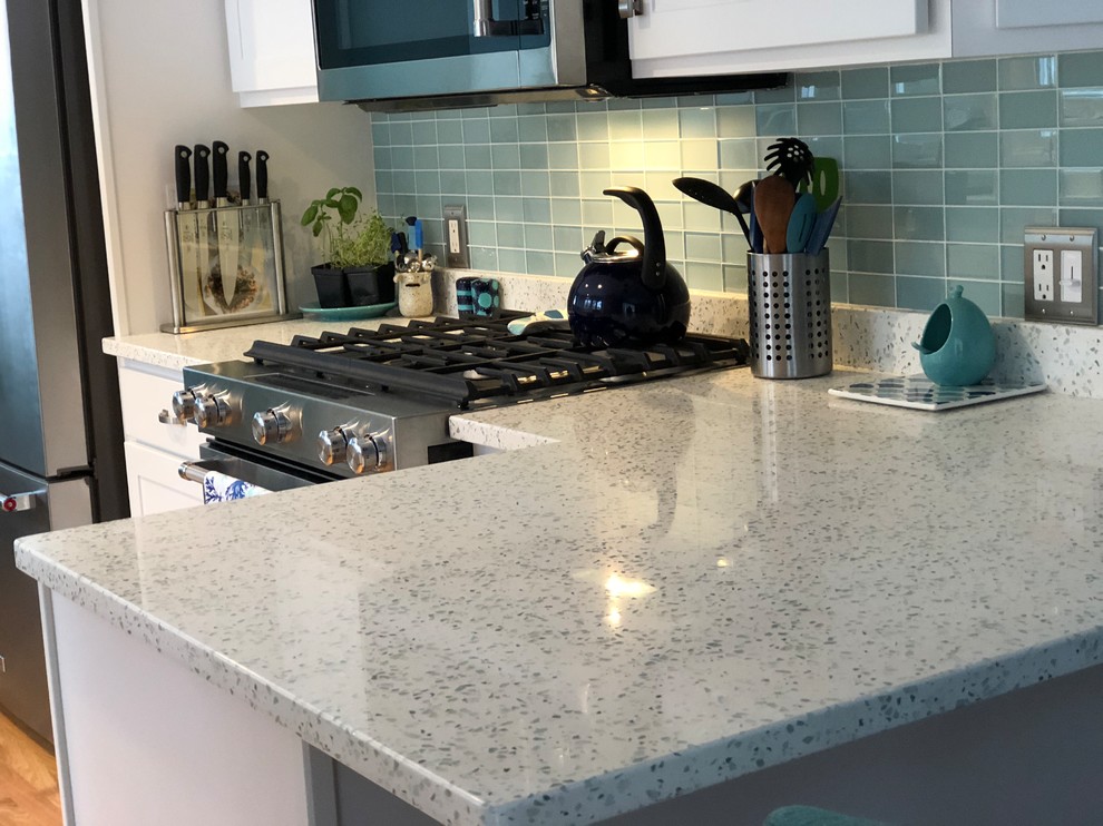 Photo of a traditional l-shaped eat-in kitchen in Providence with a double-bowl sink, recycled glass benchtops, green splashback, glass tile splashback, stainless steel appliances and a peninsula.