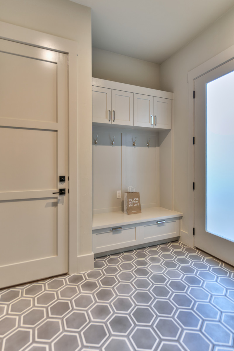This is an example of a large transitional mudroom in Austin with beige walls, vinyl floors, a single front door, a white front door and grey floor.