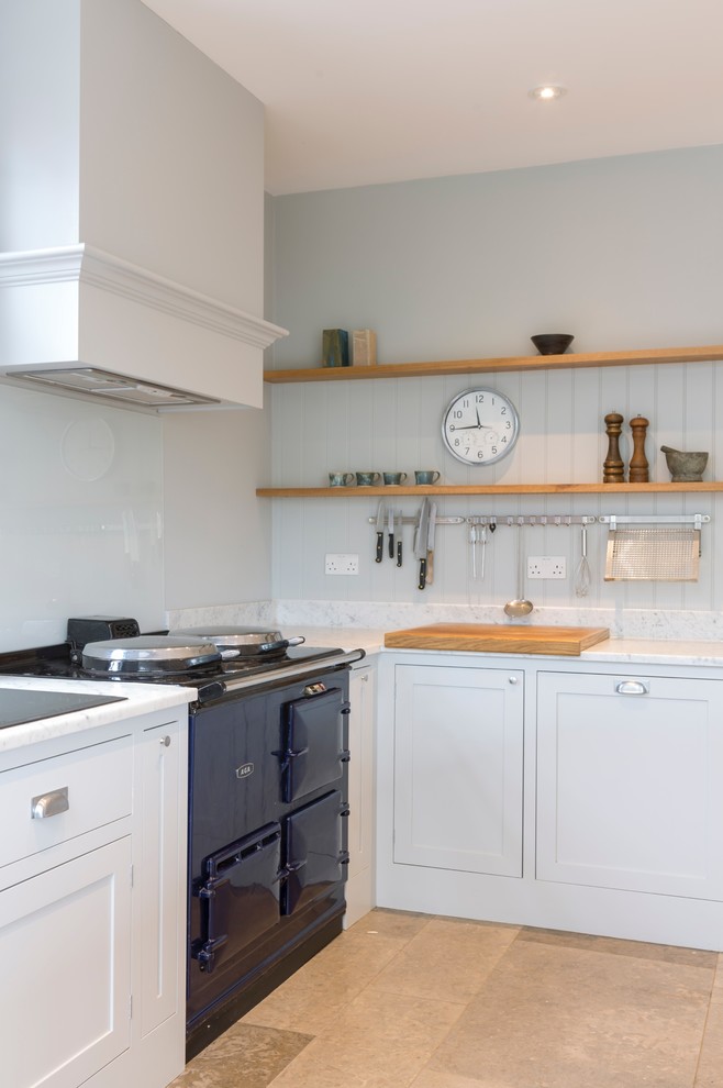 Large contemporary u-shaped open plan kitchen in Oxfordshire with a farmhouse sink, shaker cabinets, grey cabinets, solid surface benchtops, white splashback, panelled appliances, ceramic floors and with island.
