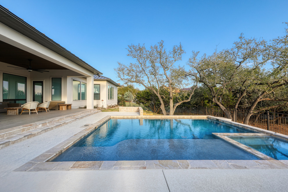Cette photo montre une grande piscine arrière tendance sur mesure avec une terrasse en bois.