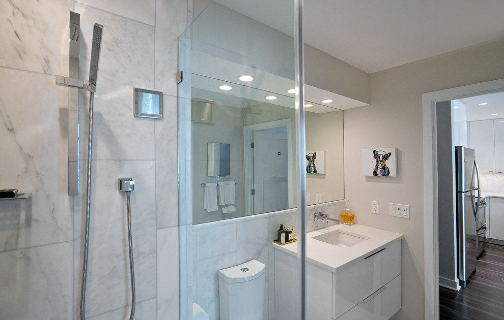 Photo of a small modern master bathroom in DC Metro with flat-panel cabinets, white cabinets, an alcove shower, a one-piece toilet, white tile, marble, white walls, marble floors, an undermount sink, engineered quartz benchtops, white floor, a hinged shower door and white benchtops.
