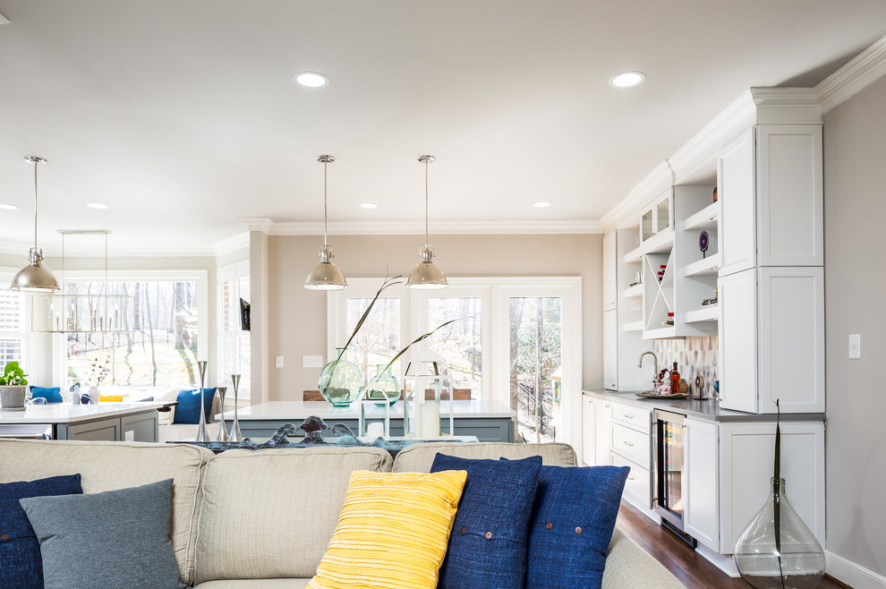 Example of a huge transitional galley medium tone wood floor open concept kitchen design in Raleigh with a farmhouse sink, flat-panel cabinets, white cabinets, quartz countertops, gray backsplash, ceramic backsplash, stainless steel appliances and two islands