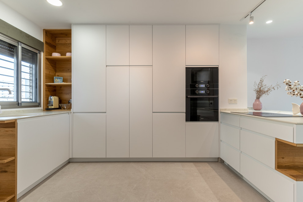 Mid-sized scandinavian u-shaped eat-in kitchen in Alicante-Costa Blanca with open cabinets, light wood cabinets, marble benchtops, black appliances, ceramic floors, with island, grey floor and white benchtop.
