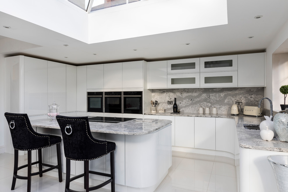 Large contemporary kitchen in Other with white cabinets, marble benchtops, white splashback, stone slab splashback and with island.