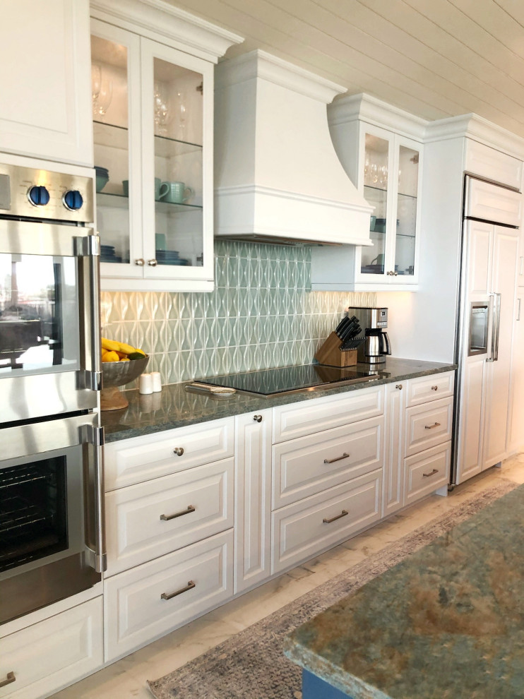 Large beach style single-wall eat-in kitchen in Tampa with an undermount sink, shaker cabinets, white cabinets, blue splashback, glass tile splashback, stainless steel appliances, porcelain floors, with island, white floor and timber.