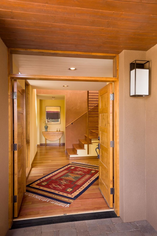 This is an example of a large front door in Albuquerque with pink walls, light hardwood floors, a double front door, a light wood front door and beige floor.