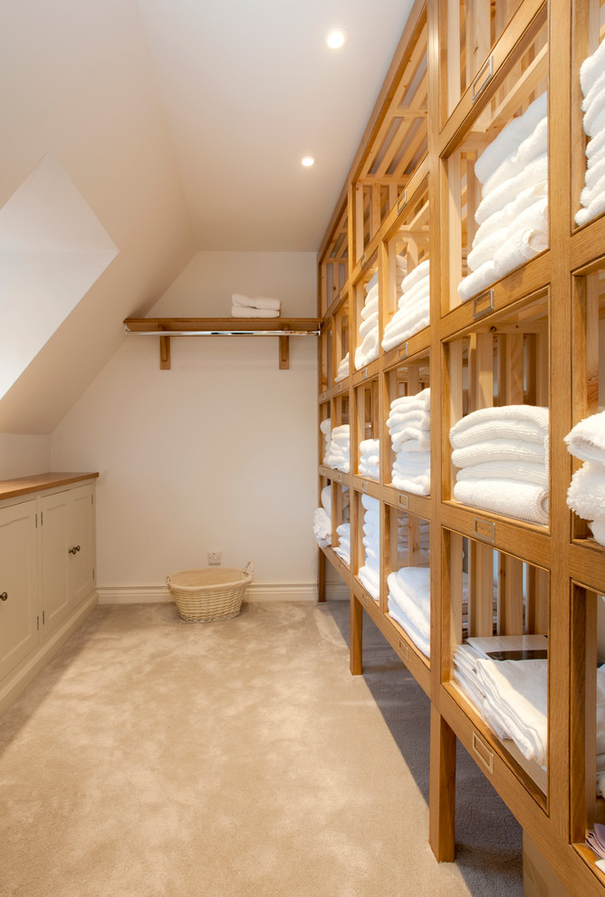 Inspiration for a country laundry room in Hampshire with open cabinets and medium wood cabinets.