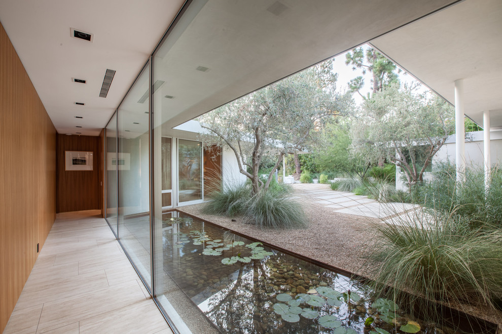 This is an example of a midcentury garden in Los Angeles with with pond.