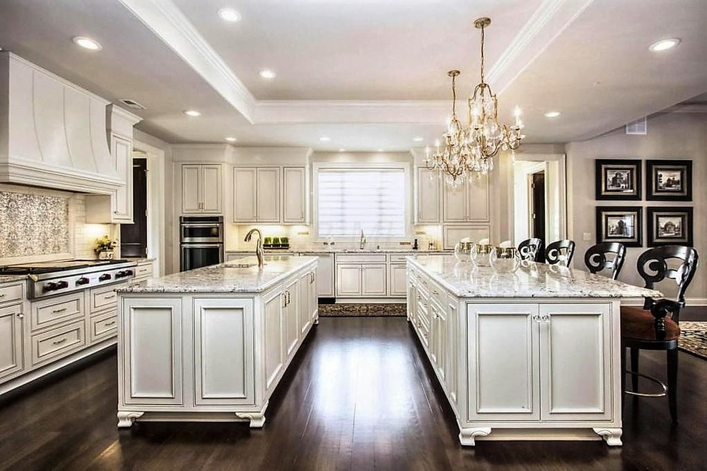 Inspiration for a large transitional u-shaped dark wood floor eat-in kitchen remodel in Columbus with a single-bowl sink, raised-panel cabinets, white cabinets, granite countertops, metallic backsplash, porcelain backsplash and two islands