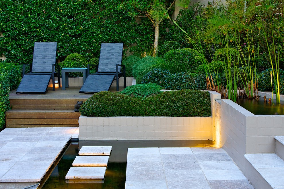 Contemporary backyard partial sun garden in Sydney with a water feature and natural stone pavers.